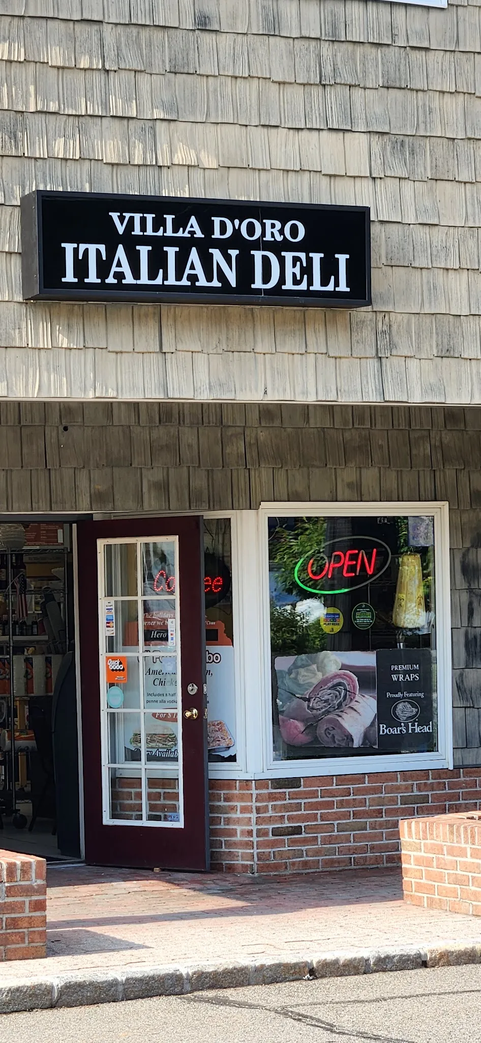 Black Villa D'oro Italian Deli sign over the shop's open door, with an OPEN sign in the window